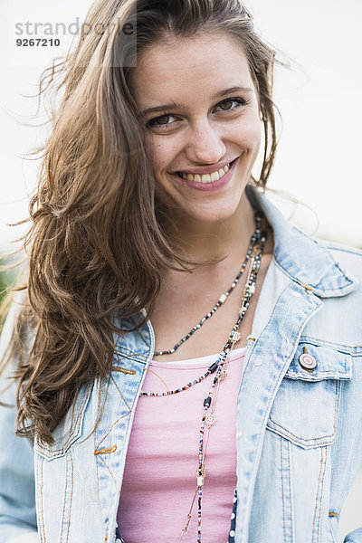 Porträt eines lächelnden Teenagermädchens in Jeansjacke
