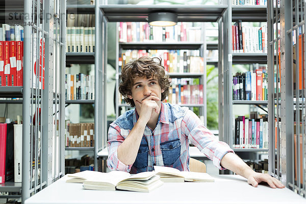 Student in einer Universitätsbibliothek beim Lesen