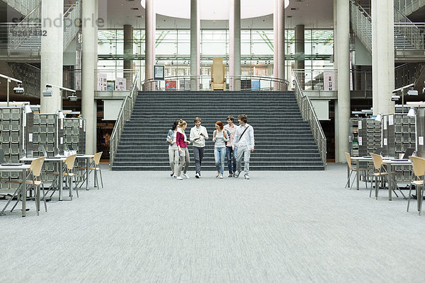 Studentengruppe zu Fuß in einer Universitätsbibliothek