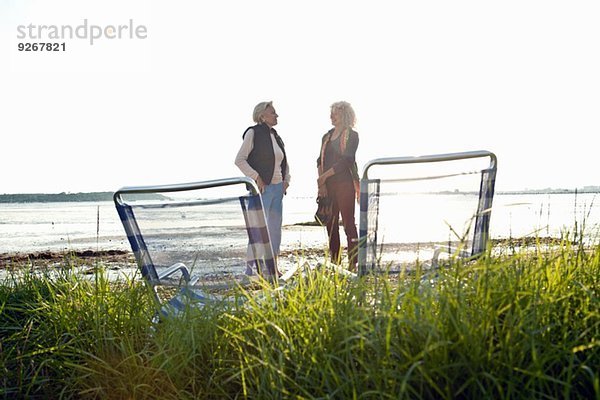 Mutter und Tochter beim Plaudern am Strand