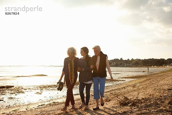 Weibliche Familienmitglieder  die am Strand spazieren gehen