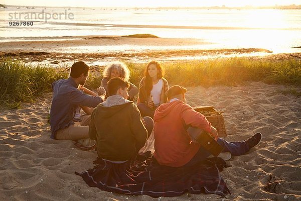 Erwachsene Freunde picknicken bei Sonnenuntergang am Strand von Bournemouth  Dorset  UK