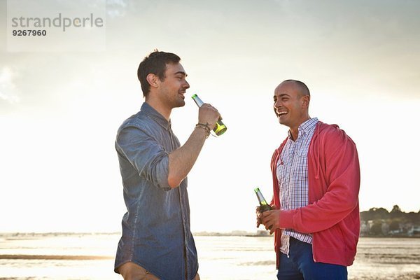 Männer trinken Bier und plaudern am Strand