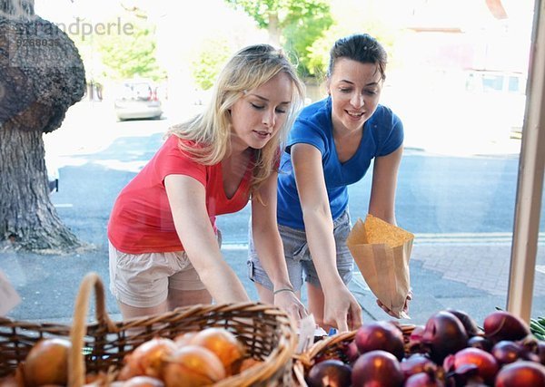 Zwei junge Frauen beim Essen am Marktstand