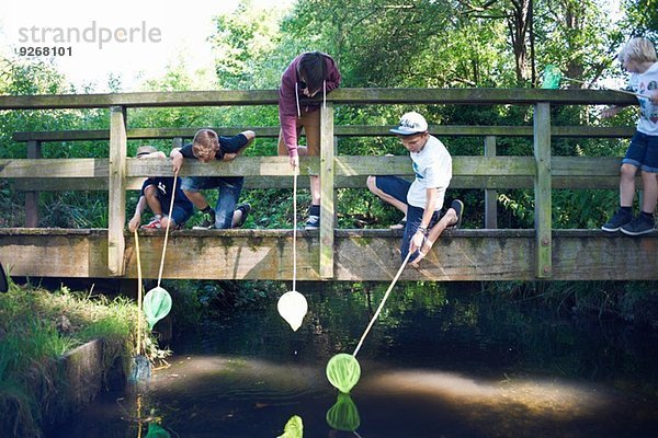 Jungen mit Fischernetzen auf der Brücke