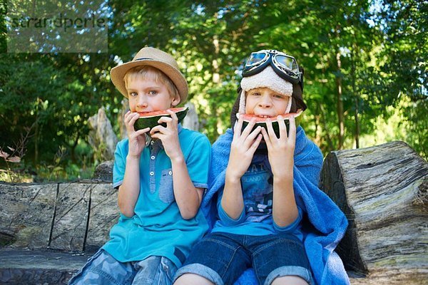 Zwei kleine Jungen essen Wassermelone im Park