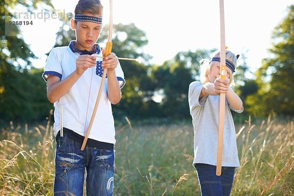 Zwei kleine Jungen mit Pfeil und Bogen