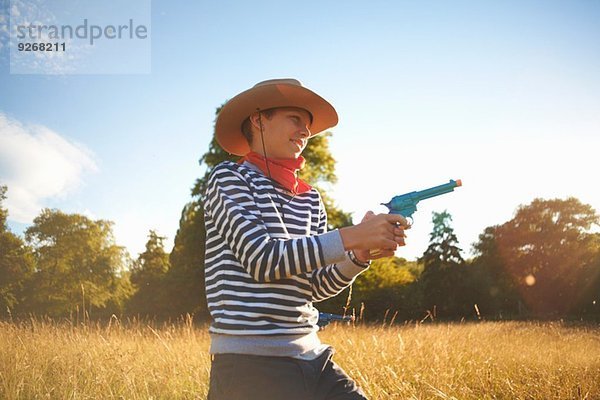 Kleiner Junge als Cowboy verkleidet  mit Spielzeugpistole