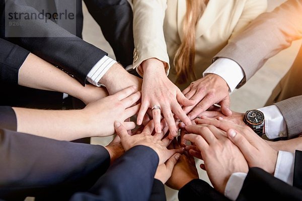 Hände einer Gruppe von Geschäftsfrauen und Männern zusammen im Kreis