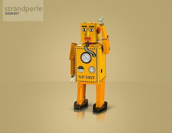 Studioaufnahme eines gelben Roboters mit angehobenem Arm