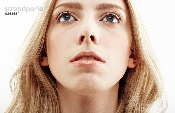 Ausschnitt aus der Nähe Studioporträt einer jungen Frau mit Blick nach oben