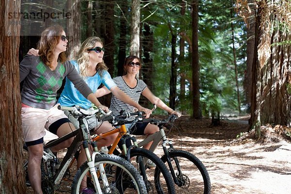 Portrait von drei Mountainbikerinnen im Wald