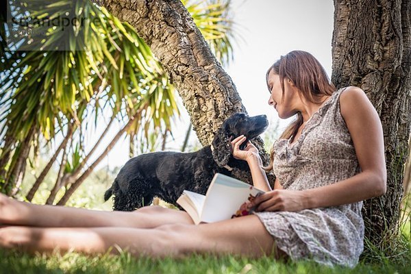 Mittlere erwachsene Frau Streichelhund im Ferienhausgarten  Capoterra  Sardinien  Italien