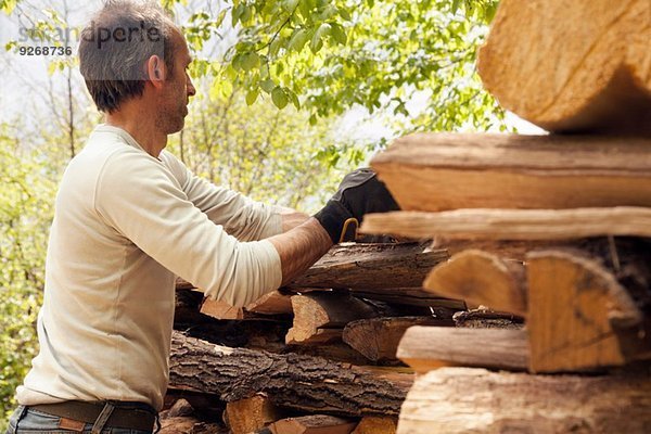 Mann beim Stapeln von Schnittholz