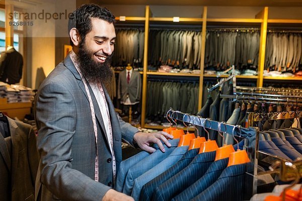 Schneiderin beim Blick auf die Business-Jacke im Herrenbekleidungsgeschäft