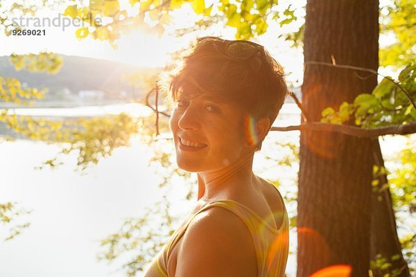 Porträt einer erwachsenen Frau am Seeufer bei Sonnenuntergang