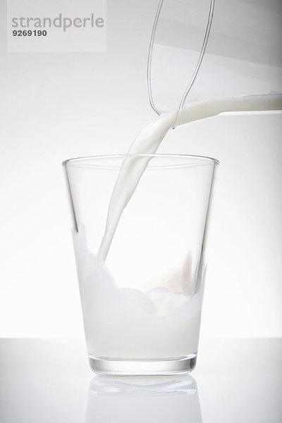 Frische Milch aus dem Krug in das Trinkglas