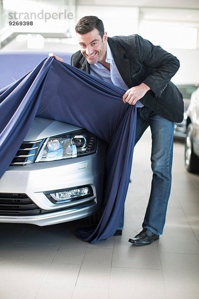 Mittlerer Erwachsener Mann entdeckt neues Auto im Autohaus