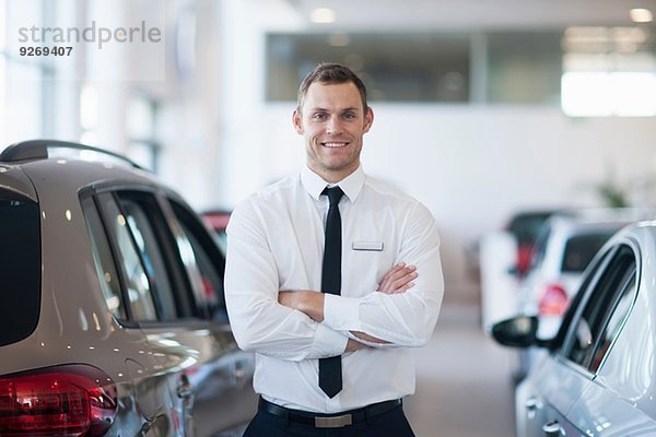 Porträt eines lächelnden Verkäufers im Autohaus
