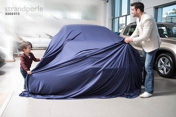 Mittlerer Erwachsener Mann entdeckt neues Auto mit Sohn im Autohaus