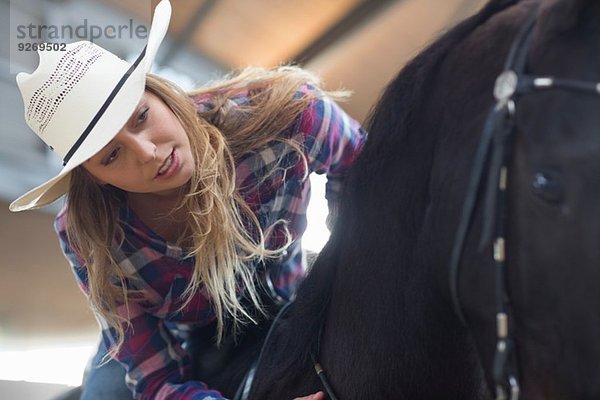 Junge Reiterin im Indoor-Paddock