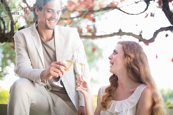 Gemeinsames Toasten mit Champagner im Gartenrestaurant