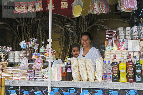 Mutter  25 Jahre  und Tochter  7 Jahre  verkaufen Süßigkeiten und Getränke aus Zuckerrohr  Puyo  Provinz Pastaza  Ecuador