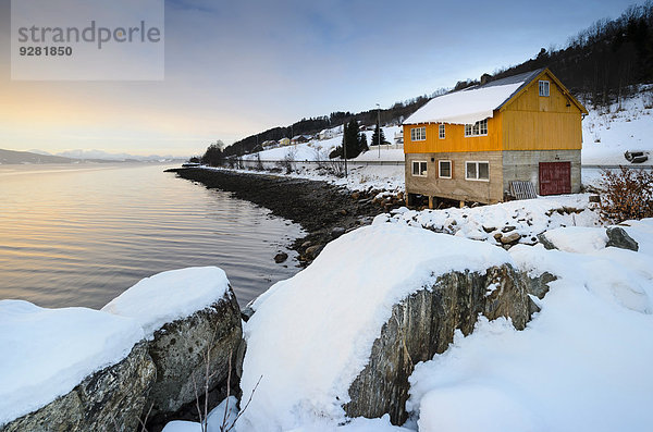 Felsbrocken Winter bedecken Küste Sonnenaufgang Fernverkehrsstraße frontal Norwegen Blockhaus typisch Atmosphäre Fjord Schnee Holzhaus