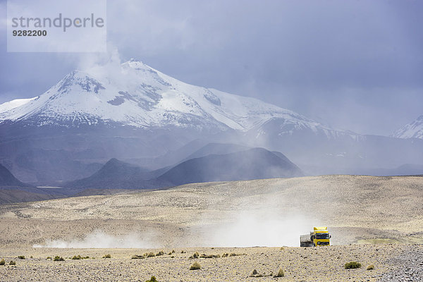 Vulkan Guallatiri und Lastwagen auf dem Weg zum Salar de surire  Altiplano  Putre  Región de Arica y Parinacota  Chile