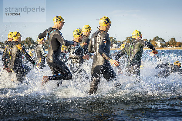 Teilnehmer eines Ironman Triathlons starten das Rennen in der Brandung  Amager Strandpark  Kopenhagen  Dänemark