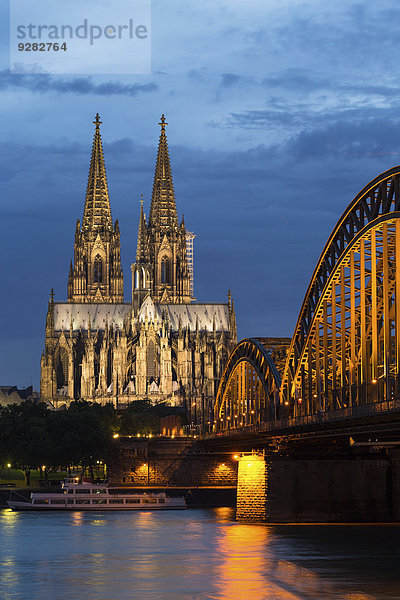 Kölner Dom mit Hohenzollernbrücke in der Abenddämmerung  vorne Rhein  Köln  Nordrhein-Westfalen  Deutschland