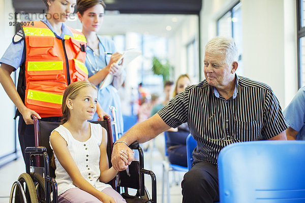 Mann mit der Hand der Enkelin im Krankenhaus