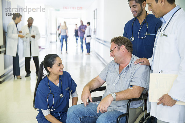 Arzt und Krankenschwestern im Gespräch mit dem Patienten im Krankenhaus