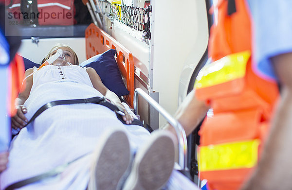 Rettungssanitäter bei der Untersuchung des Patienten auf der Trage im Krankenwagen