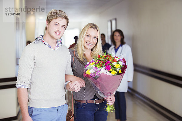 Paar mit Blumenstrauß im Krankenhaus