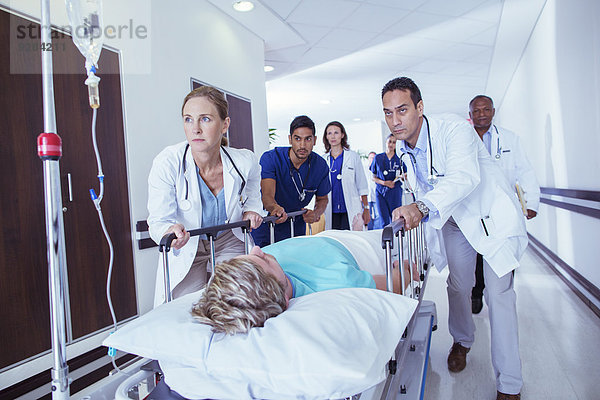 Ärzte und Krankenschwestern  die Patienten in den Flur des Krankenhauses bringen.