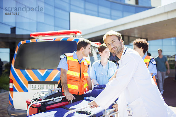 Arzt mit Sanitätern außerhalb des Krankenhauses