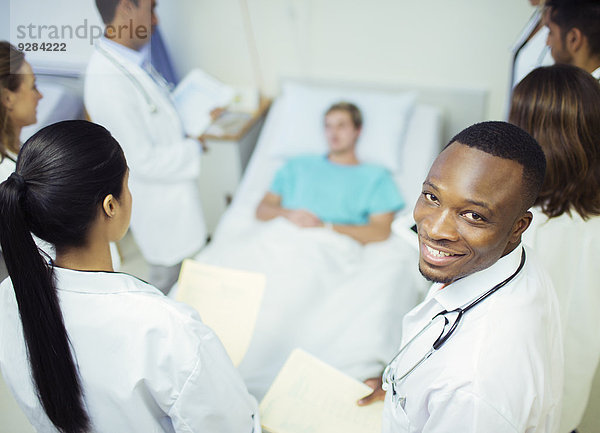 Arzt steht mit Bewohnern im Krankenhauszimmer