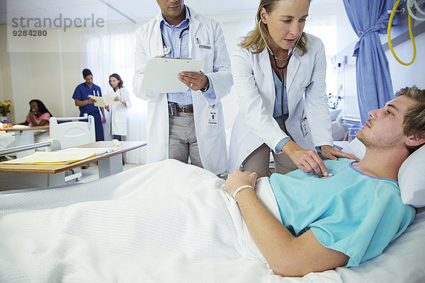 Ärzte untersuchen Patienten im Krankenhauszimmer