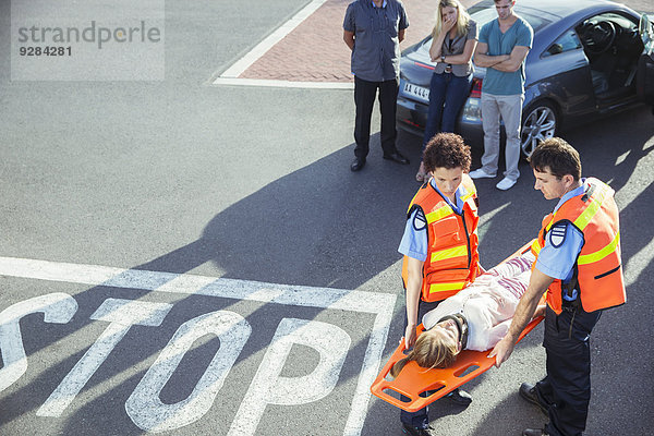 Rettungssanitäter  die den Patienten auf der Trage tragen