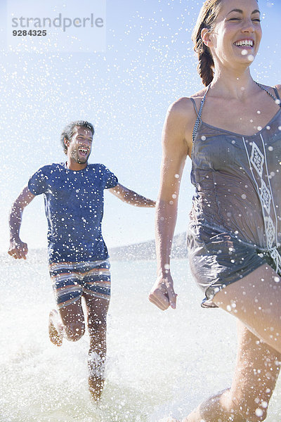 Pärchenspritzen im Wasser am Strand