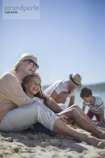 Gemeinsames Sitzen der Familie am Sandstrand