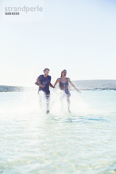 Pärchenspritzen im Wasser am Strand