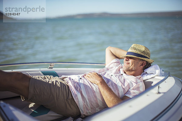 Älterer Mann entspannt im Boot auf dem Wasser