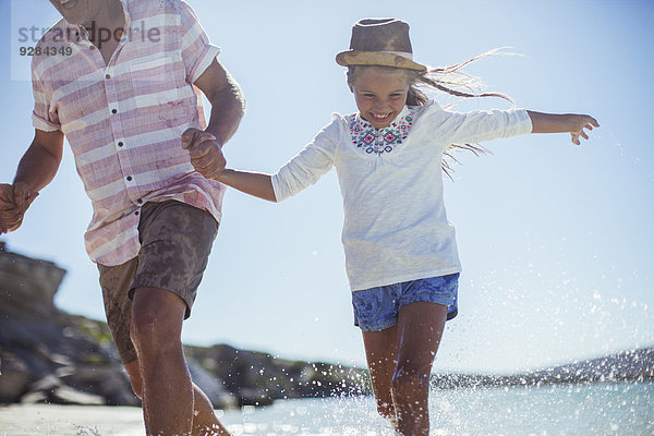 Familienlauf im Wasser am Strand