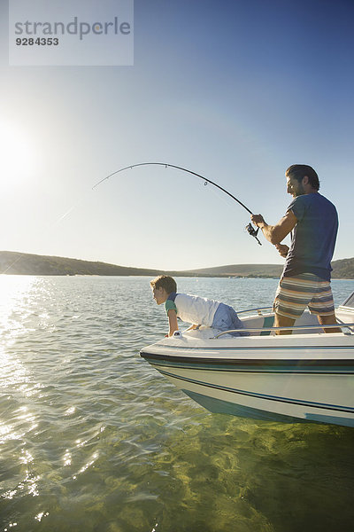 Vater und Sohn fischen auf dem Boot