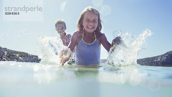 Junges Mädchen und Bruder beim Planschen im Wasser