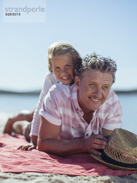 Großvater und Enkelin beim Spielen am Strand