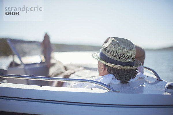 Älterer Mann entspannt im Boot auf dem Wasser