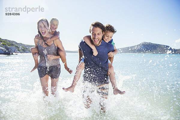 Familienlauf im Wasser am Strand